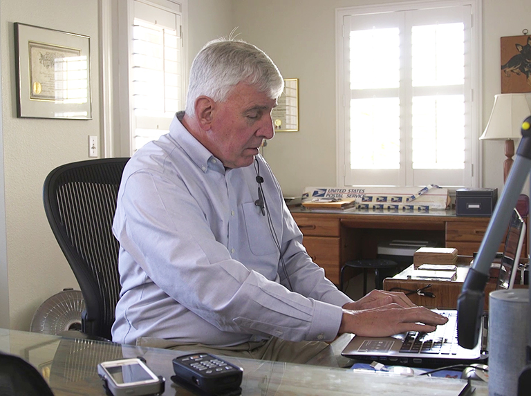 Adult man using laptop and headphones at home office
